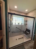 Stylish bathroom renovation showcasing a sleek shower and ample storage solutions.