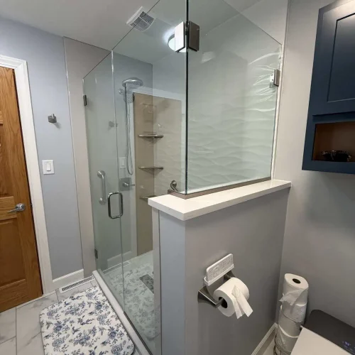 Remodeled downstairs bathroom in Crown Point with a white soaking tub, Horizon Beige wall surround, slate vanity, and quartz countertop.